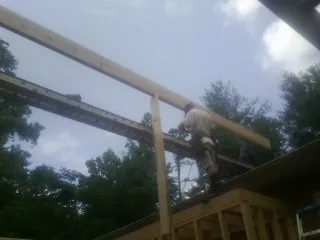 Carpenter setting a ridge beam over a new addition frame — Ice Dam Removal by Roofing Brothers in Jermyn