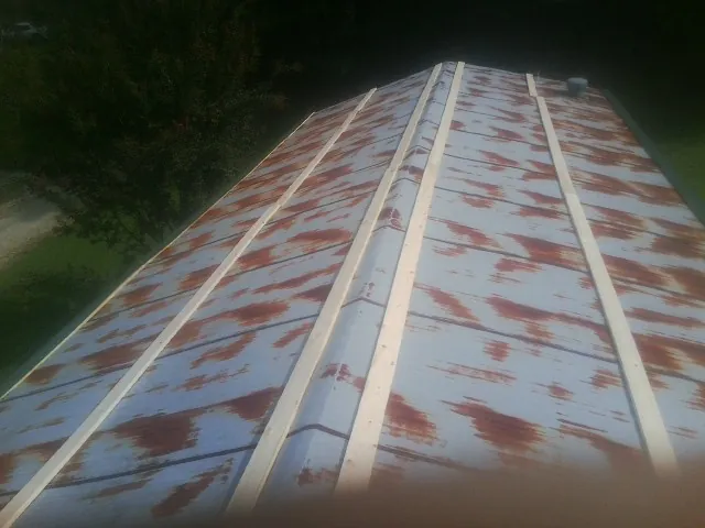 Rusted metal roof panels with new wood purlins before replacement — Storm Damage Roof Repair in Jermyn by Roofing Brothers