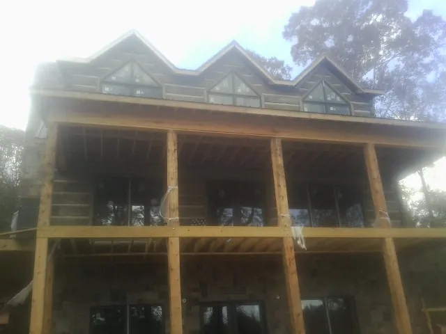 Dormers and porch framing on a large log home under construction — Roof Coating work by our crew in Jermyn