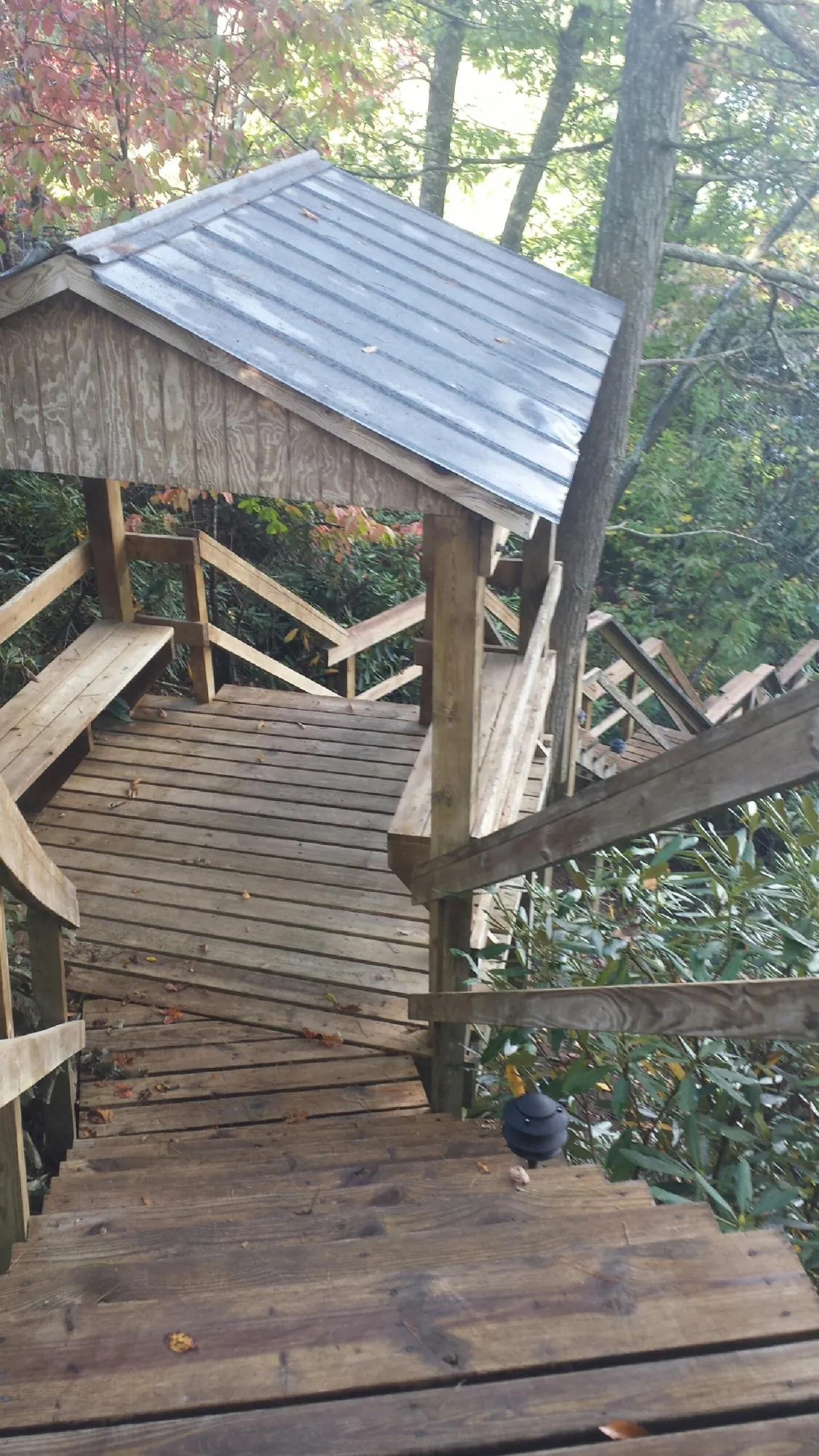 Metal roofed shelter over wooden steps on a wooded walkway — Skylight Repair & Installation work by our crew in Jermyn