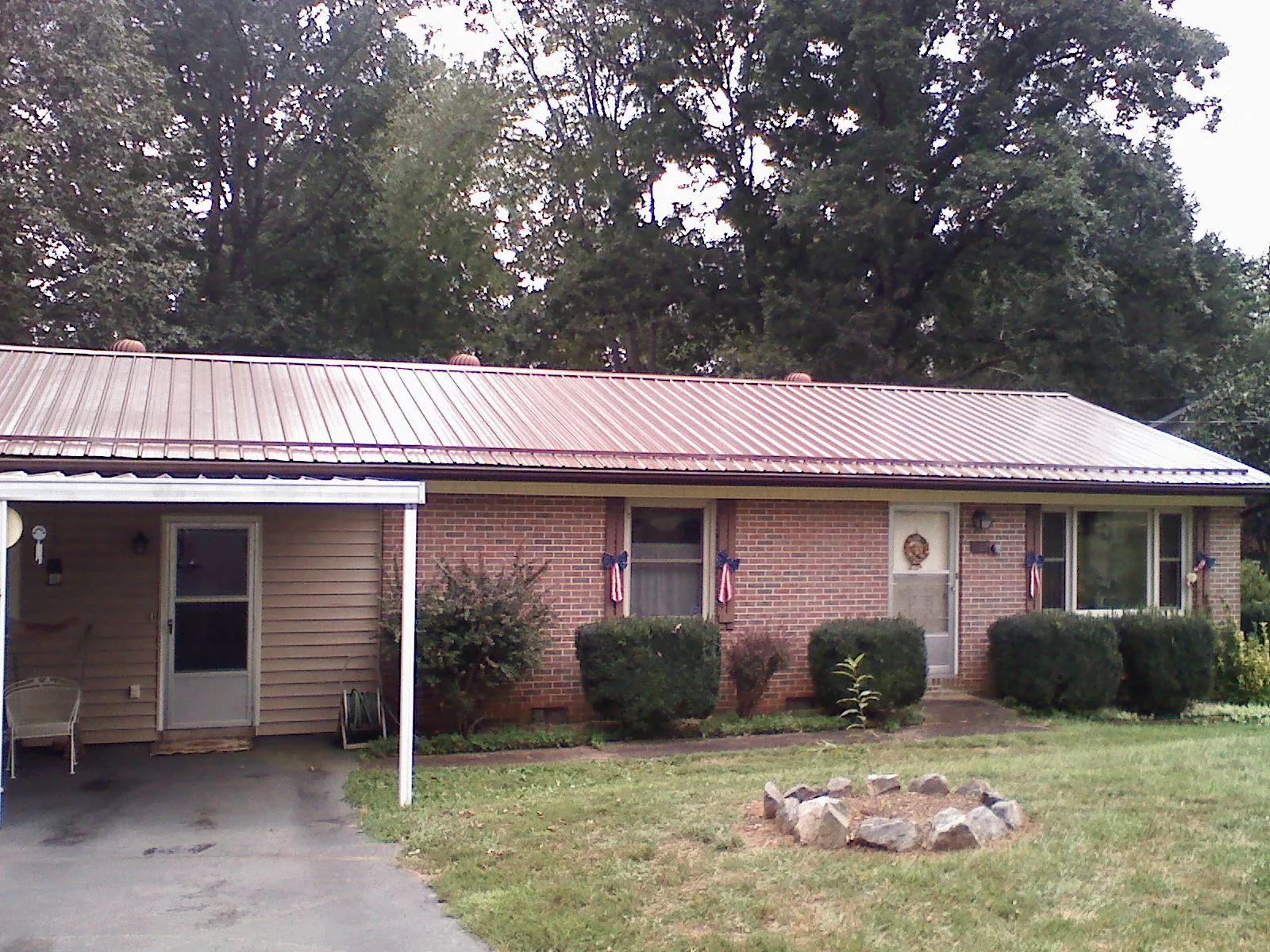 Bronze metal roof and carport on a brick ranch home — Roof Repair work by our crew in Jermyn
